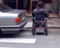 L'automobile sosta sulle zebre pedonali e impedisce l'attraversamento a chi si muove in carrozzina.