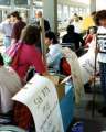 Carrozzine, persone e cartelloni.